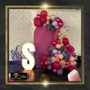 a balloon arch with a large letter S